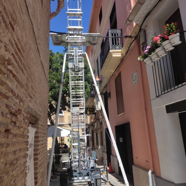 Fotografía de una mudanza con una plataforma elevadora en una calle estrecha